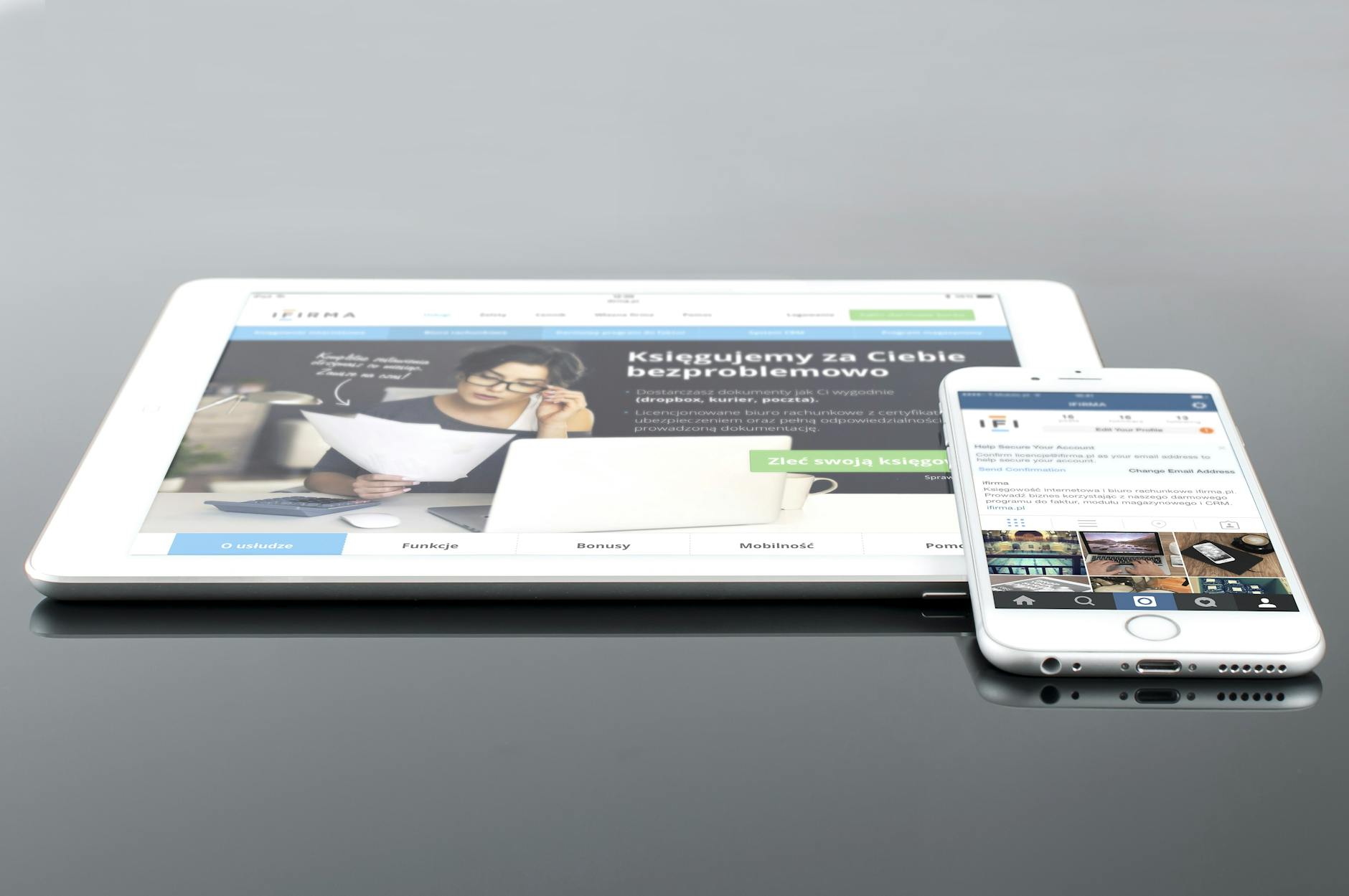 Tablet and phone showing travel content on a reflective surface